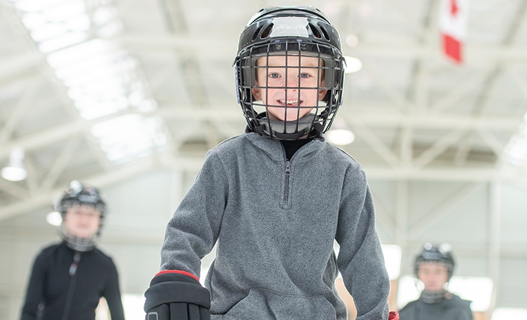 child with hockey helmet and gloves