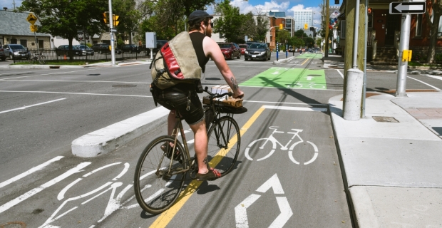 A cyclist in the summer travelling in a bike lane on O'Connor Street