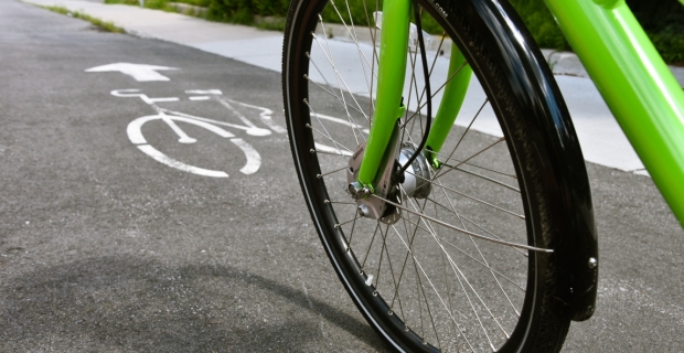 Close-up of a front wheel of a bike travelling in a bike lane