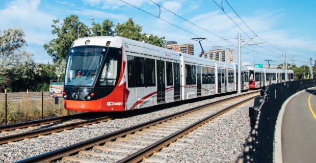 Un train léger sur rail dans un virage en été