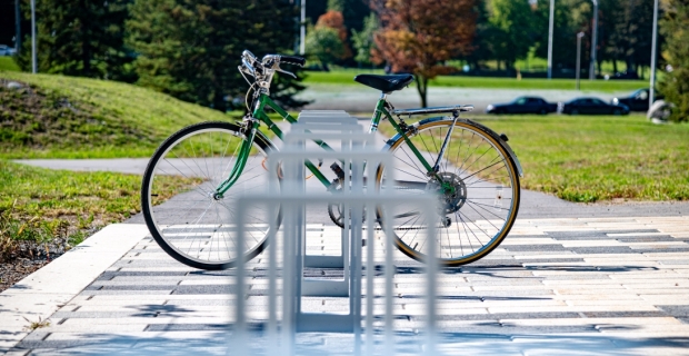 A bike locked up at a bike stand on a sunny day