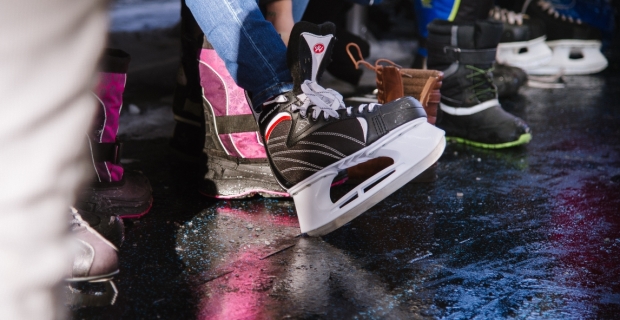 A group of people putting on skates at an outdoor rink