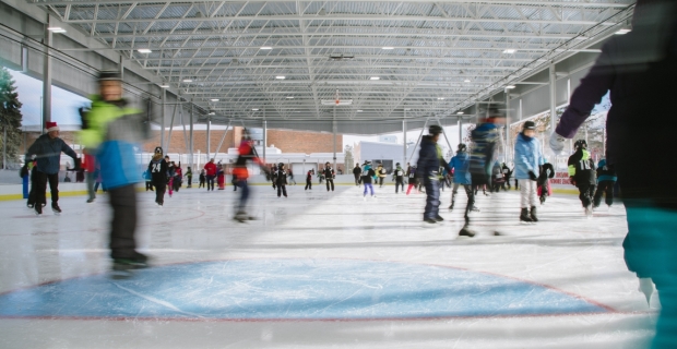 Une foule de patineurs sur la glace d’une patinoire extérieure couverte