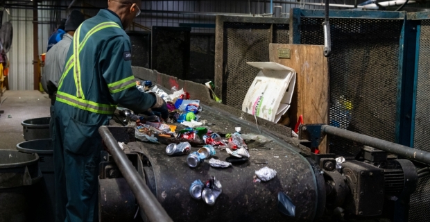 Travailleur triant des matériaux recyclés à l’installation de recyclage Cascades