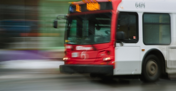 An OC Transpo bus driving by with motion blur