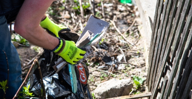 Un travailleur plaçant des déchets dans un sac-poubelle