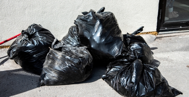 Cinq sacs poubelles pleins sur le trottoir