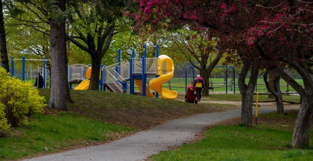 Une allée menant à une structure de jeu dans un espace boisé du parc Craig-Henry