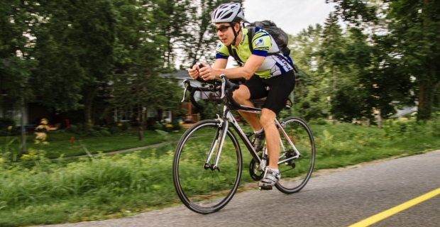 Un cycliste en tenue de course circulant sur une piste cyclable