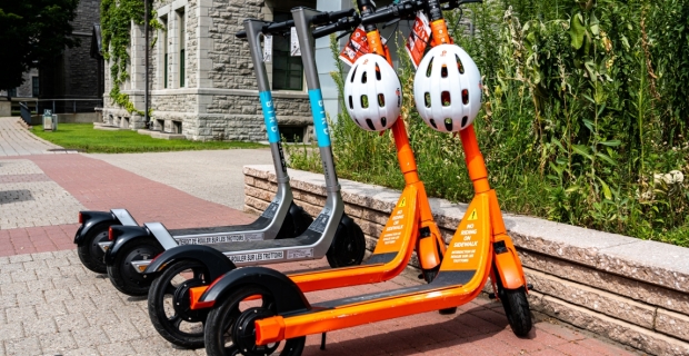 Quatre trottinettes électriques devant l’hôtel de ville.