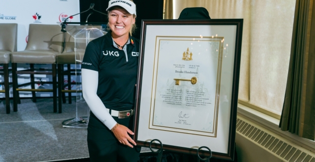 Golfer Brooke Henderson posing for a picture with her Key to the City plaque.