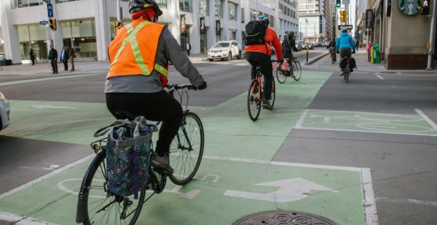 Une rangée de cyclistes pendant le trajet du matin sur une voie cyclable séparée de l’avenue Laurier