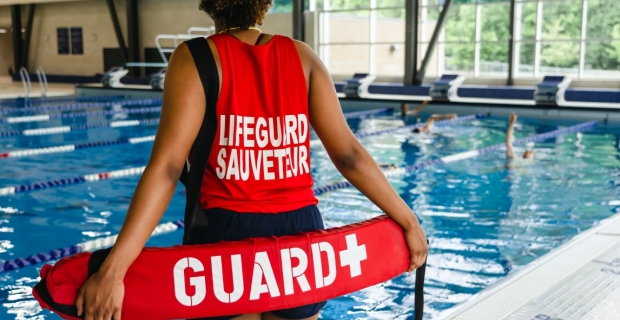 A lifeguard on deck of an indoor pool at Richcraft Recreation Complex