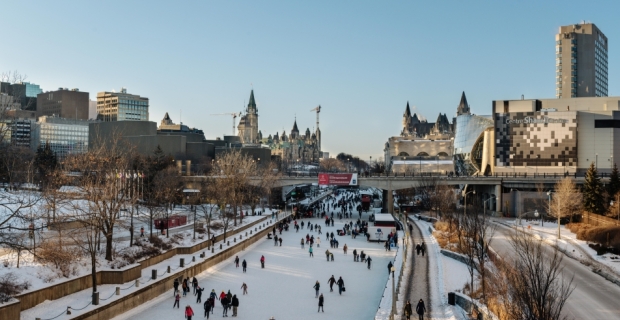 A panoramic view of the Rideau Canal in winter with many skaters and visitors