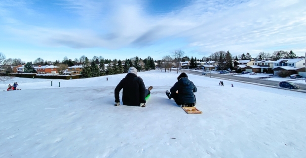 Deux lugeurs au sommet de la pente de glissade du parc Neil-Nesbitt