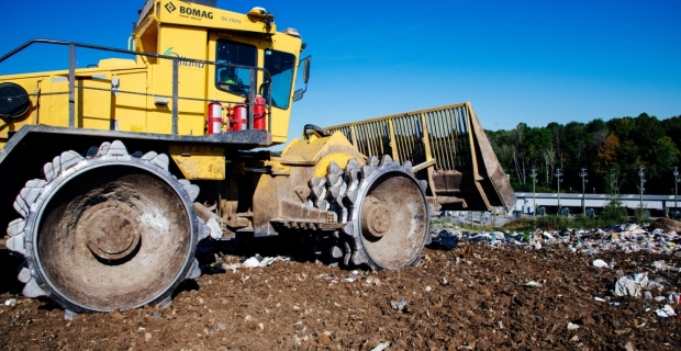 Gros plan sur un bouteur lourd au sommet d’une colline de déchets