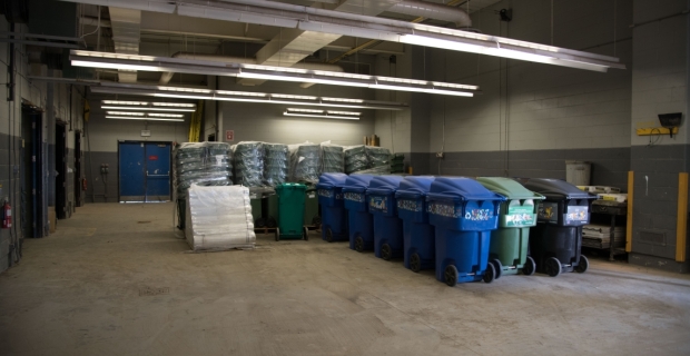 A row of recycling bins and compost bins