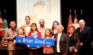 Mayor and guests holding a street sign 