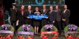 Mayor and guests holding a street sign 