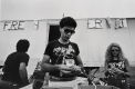 Black and white photograph of three figures at a festival