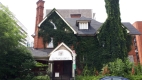 This elaborate Queen Anne Revival style red brick house is located at 46 Cartier Street in Centretown. The house features a wrap-around front porch and decorative brick work. 